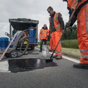 Mannen werken aan de weg