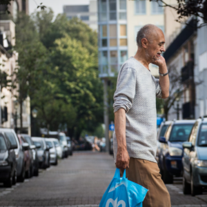 Man loopt op straat met tas in zijn hand