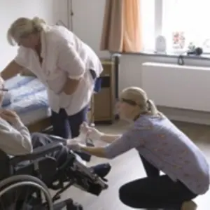 Man in rolstoel wordt verpleegd
