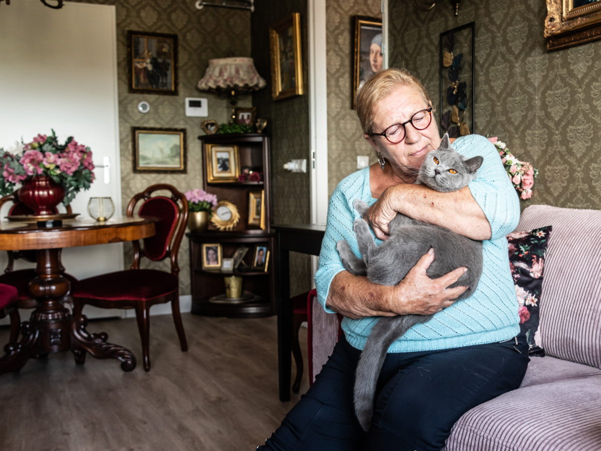 Oudere op bank met kat